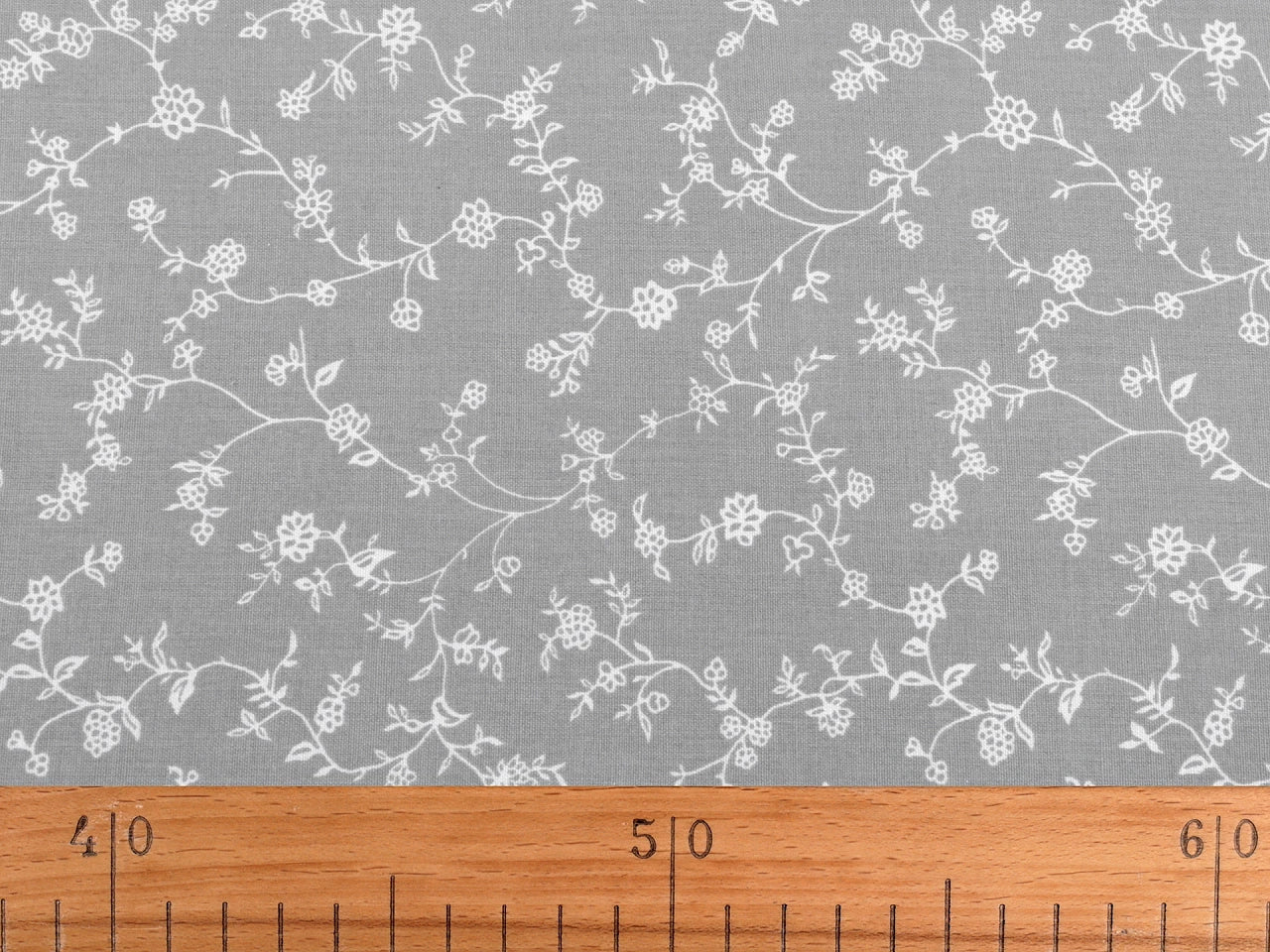 Attēls ar 100% Kokvilnas audums - baltas ziedošas stīgas uz sarkana 125 g/m² – pieejams Šarlotes audumi