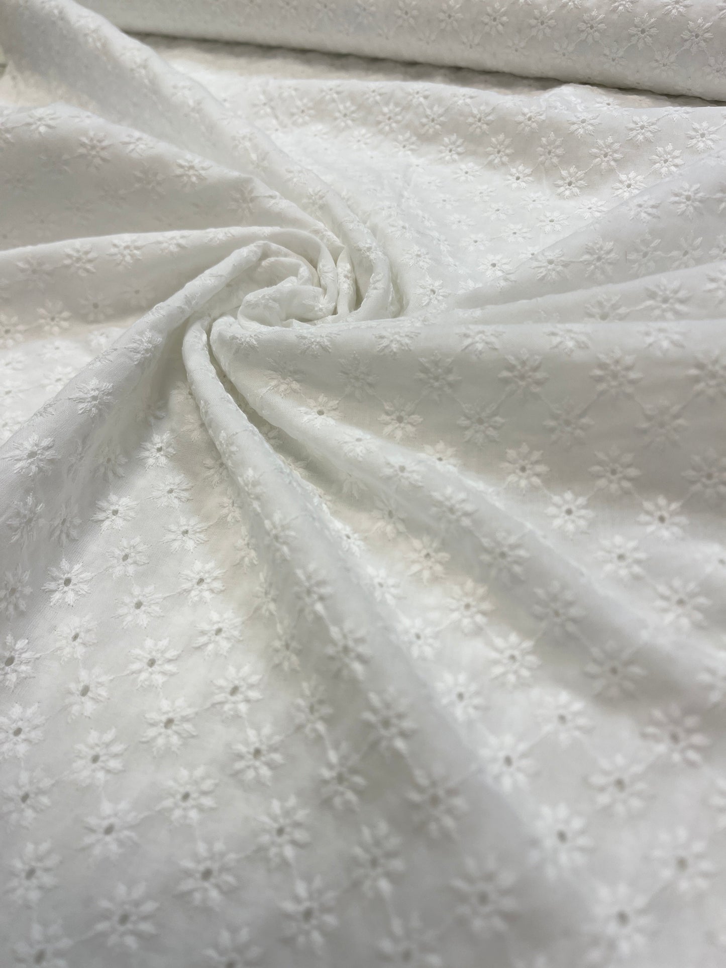 Attēls ar Izšūts kokvilnas audums - balts puķīšu motīvs 100 g/m² – pieejams Šarlotes audumi