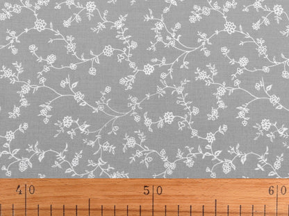 Image d’un tissu 100 % coton - tiges fleuries blanches sur fond rouge, 125 g/m² – disponible chez Šarlotes audumi