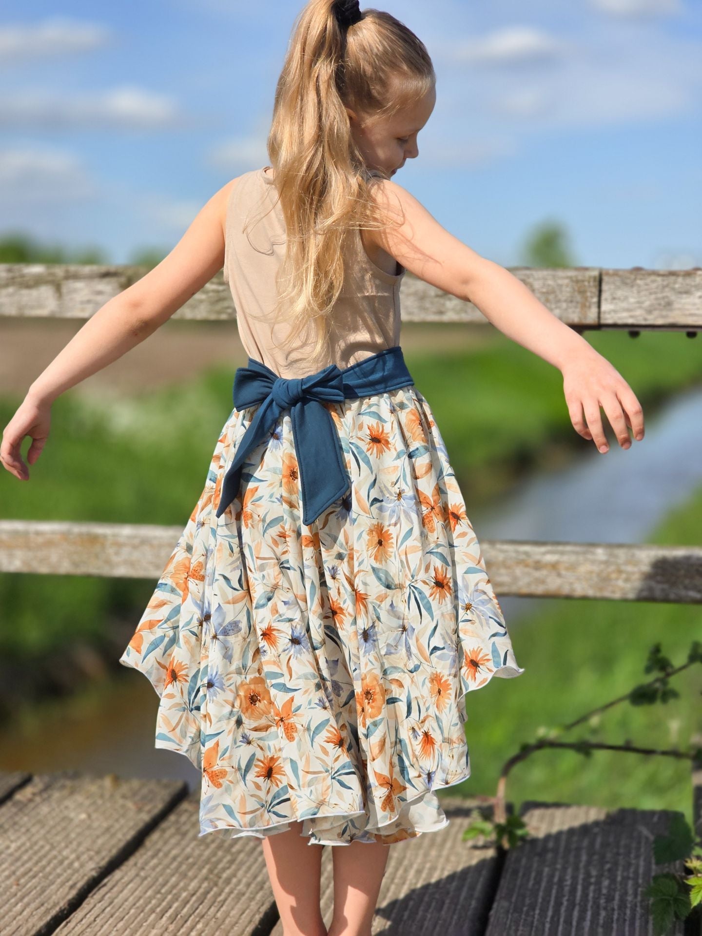Image of 100% viscose fabric with a blue and orange floral motif – available online at Šarlotes audumi