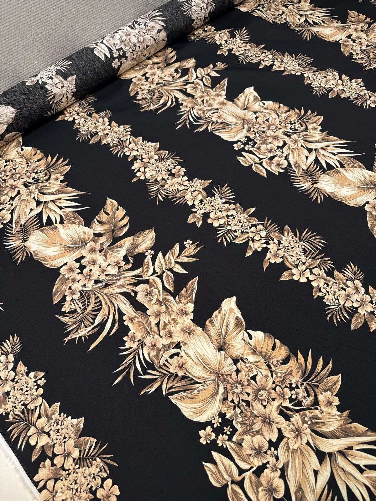 Image of Italian cotton fabric with a tropical floral pattern on a black background - available online at Šarlotes audumi