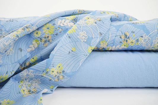 Attēls ar Izšūts kokvilnas audums - dzetenas puķes uz zila 115 g/m² – pieejams Šarlotes audumi