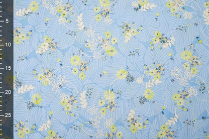 Image d’un tissu en coton brodé - fleurs jaunes sur fond bleu 115 g/m² – disponible chez Šarlotes audumi