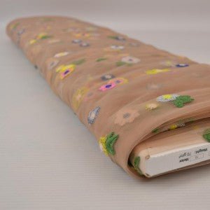 Pilt tikitud lilledega tüllkangast – virsikutoonis 70 g/m² – saadaval Šarlotes audumi
