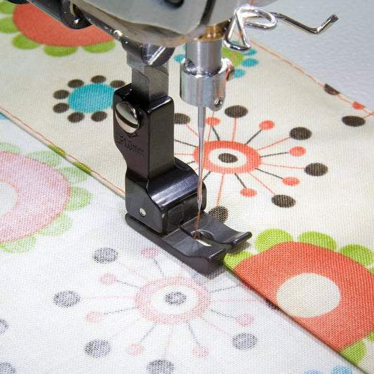 Attēls ar Rūpniecisko šujmašīnu pēdiņa - kompensējošā kreisā, 1,0 mm ar PTFE pārklājumu – pieejams Šarlotes audumi